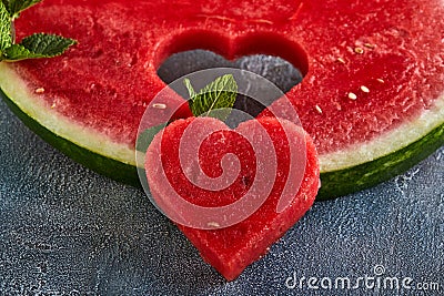 Composition with ripe watermelon, mint leaves and a heart carved in a slice of watermelon. Concept for valentines day Stock Photo