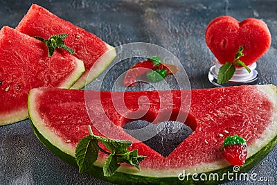 Composition with ripe watermelon, mint leaves and a heart carved in a slice of watermelon. Concept for valentines day Stock Photo