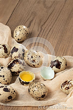 Composition of several quail eggs on decorative fabric on a wooden table close-up, copy space, virtical banner, flatlay Stock Photo