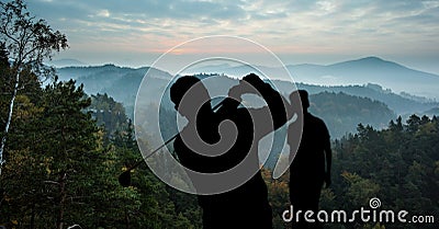 Composition of silhouette of golf players over landscape, clouds on blue sky with copy space Stock Photo