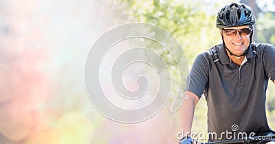 Composition of smiling fit caucasian man riding bicycle in forest with blur Stock Photo