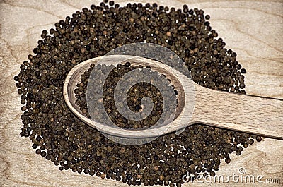 Composition of a spoon with black pepper. Stock Photo