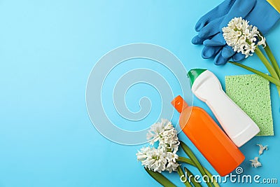 Composition with spring flowers and cleaning supplies on blue background, flat lay. Space for text Stock Photo