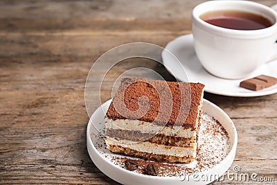 Composition with tiramisu cake and tea on wooden table Stock Photo