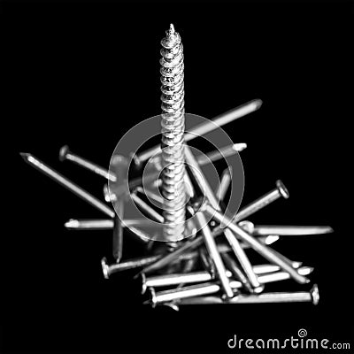 Composition is towering over a pile of nails macro isolated on a black background Stock Photo