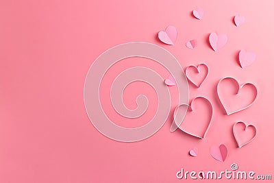 Composition for Valentine`s Day February 14th. Delicate pink background and pink hearts cut out of paper. Greeting card Stock Photo