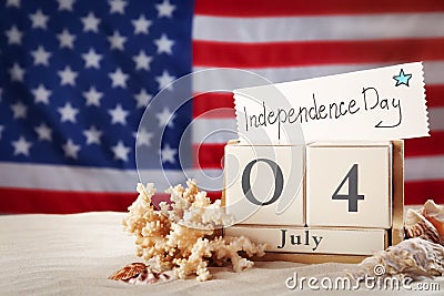 Composition with wooden calendar and card on sand against USA flag. Happy Independence Day Stock Photo