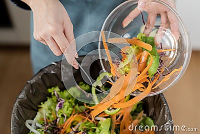Compost the kitchen waste, recycling, organic meal asian young household woman scraping, throwing food leftovers into the garbage Stock Photo