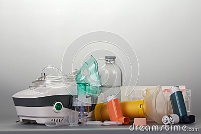 Compressor and portable inhalers, replaceable dispenser, ampoules and baby mask, on grey Stock Photo