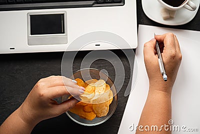 Mindless snacking, junk food. Woman eating chips Stock Photo