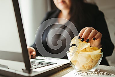 Woman eating junk food, snacking with chips Stock Photo