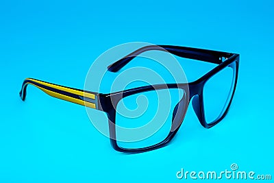 Computer eye protection glasses with a yellow shackle close up on a blue background, isolation Stock Photo