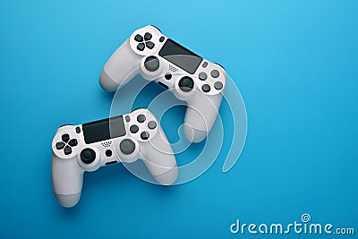 A Computer game competition. Gaming concept. Two white joysticks on blue background. Copy space. Top view Stock Photo