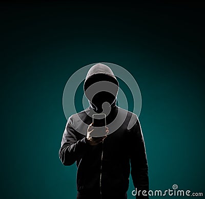 Computer hacker in hoodie. Obscured dark face. Data thief, internet fraud, darknet and cyber security concept. Stock Photo