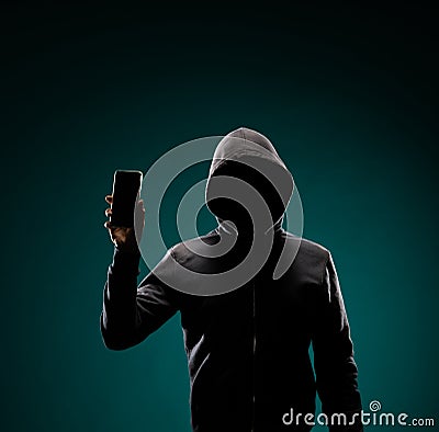 Computer hacker in hoodie. Obscured dark face. Data thief, internet fraud, darknet and cyber security concept. Stock Photo