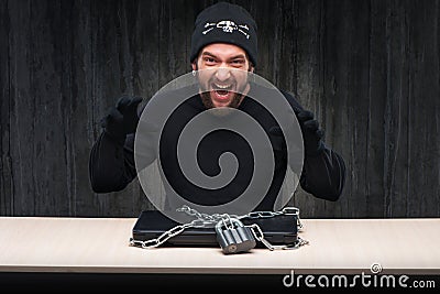 Computer hacker with locked laptop Stock Photo