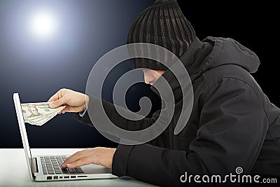 Computer hacker stealing money in the darkness Stock Photo