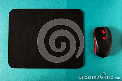 Computer mat and computer mouse on a turquoise background, close-up, instrument Stock Photo