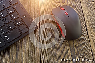 Computer mouse and keyboard on a wooden background, sun, close-up, keyboard Stock Photo