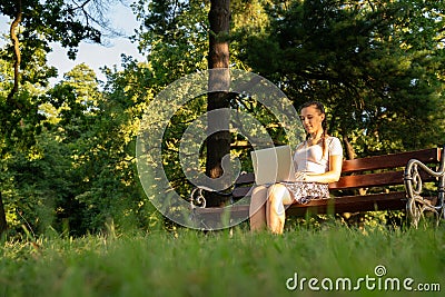 Computer outdoor. Student girl working on laptop, tablet in summer park. Woman person business nature outside with Stock Photo