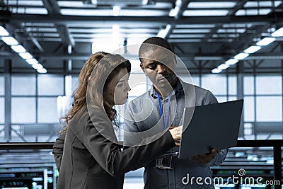 Computer scientists in data center use notebook, integrating green technologies Stock Photo