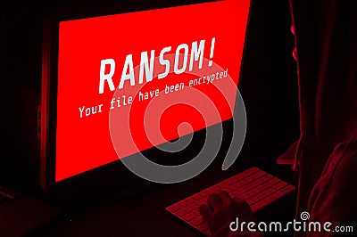 Computer screen with ransomware attacks alert in red and a man k Stock Photo