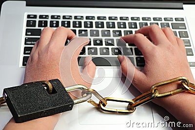 A computer is tied to a man`s hand by a sturdy chain. Stock Photo