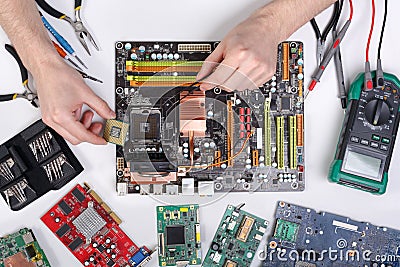 Computer upgrade. Technician plug in microprocessor to motherboard Stock Photo