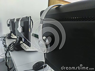 Computers placed in line on a table in a computer classroom Stock Photo