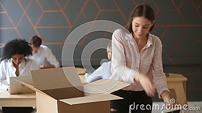 Conceito de trabalho novo, jovem mulher que desembala a caixa na mesa de escritório Conceito de trabalho novo, jovem mulher que desembala a caixa na mesa de escritório