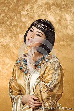 Conceived Beautiful woman like Egyptian Queen Cleopatra on golden background Stock Photo