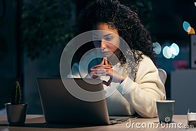 Concentrated african business woman thinking while working with laptop in the office at home Stock Photo