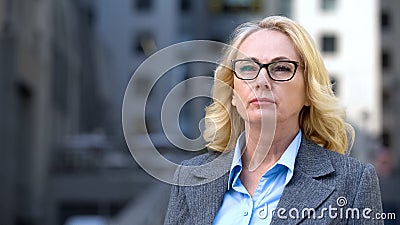 Concentrated aged business woman eyeglasses thinking of work, company strategy Stock Photo
