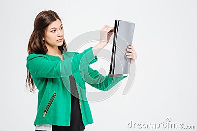 Concentrated beautiful woman in green jacket holding clipboard and drawing Stock Photo