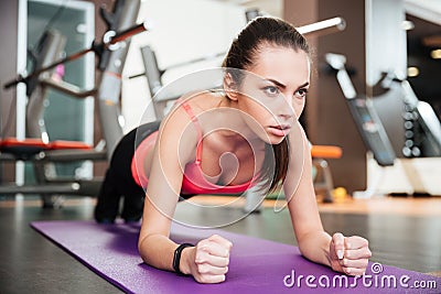 Concentrated beautiful young sportswoman doing plank exercise Stock Photo
