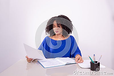 Concentrated beautiful young woman reading work material Stock Photo