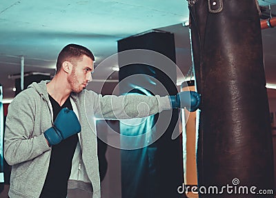 Concentrated boxer direct hit with punching bag Stock Photo