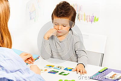 Concentrated boy plays developing game at table Stock Photo