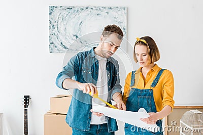 Concentrated couple with measuring tape and blueprint Stock Photo