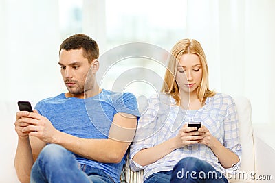 Concentrated couple with smartphones at home Stock Photo