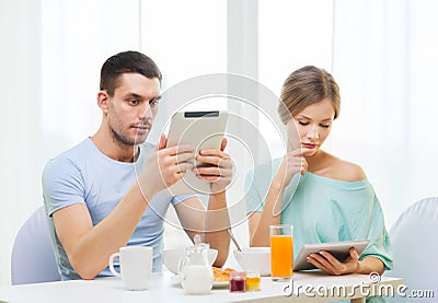 Concentrated couple with tablet pc reading news Stock Photo