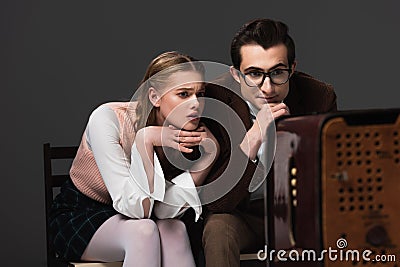 concentrated couple in vintage outfit watching Stock Photo