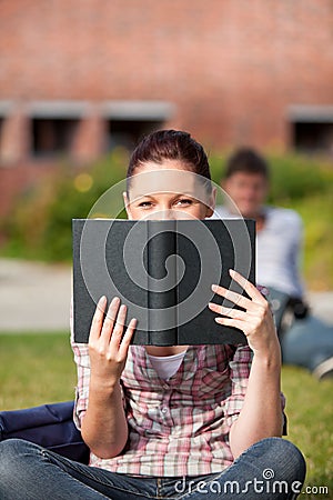 Concentrated female student reading a book outdoor Stock Photo