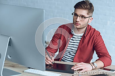 Concentrated freelancer man with graphic tablet sitting Stock Photo