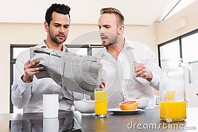 Concentrated gay couple reading newspaper Stock Photo
