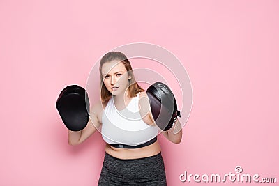Concentrated overweight girl exercising with boxing Stock Photo