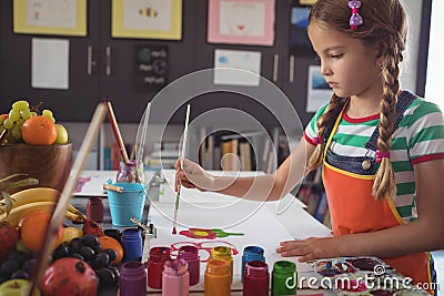 Concentrated girl painting at desk Stock Photo