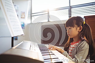 Concentrated girl practicing piano in class Stock Photo