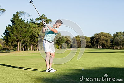 Concentrated golfer man taking shot Stock Photo