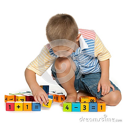 Concentrated little boy with blocks on the floor Stock Photo